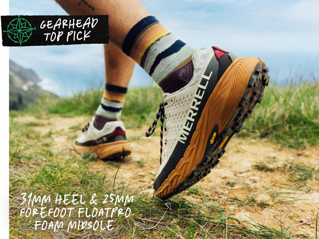 Closeup of a merrell shoe as someone walks on a trail. text overlay reads: gearhead top pick 31mm heel & 25mm forefoot floatpro foam midsole.